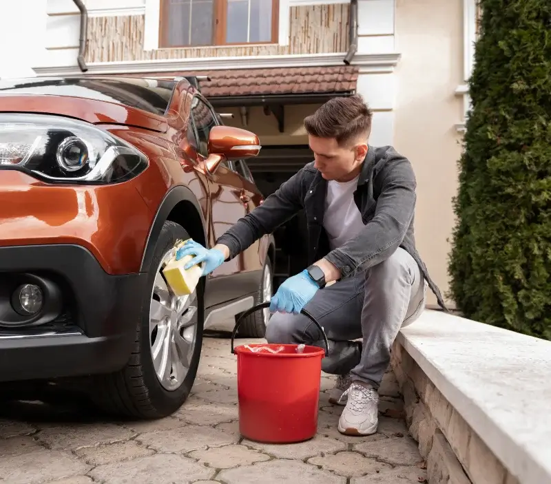 Lavage auto à domicile Grilly : professionnel intervenant sur un véhicule